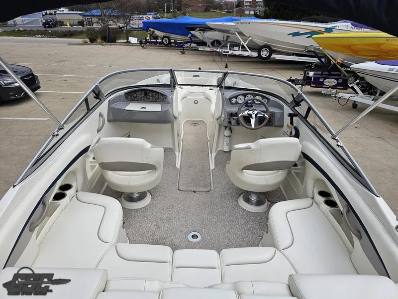 Slide: The Image of 2013 Stingray 225 LR boat interior with white seating and dashboard view. - 44