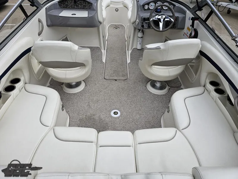 Slide: The Image of Interior of a 2013 Stingray 225 LR boat with white seating and modern dashboard. - 45