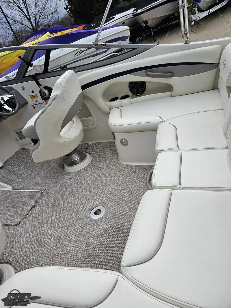 Slide: The Image of 2013 Stingray 225 LR boat interior with white seating and carpeted floor. - 48