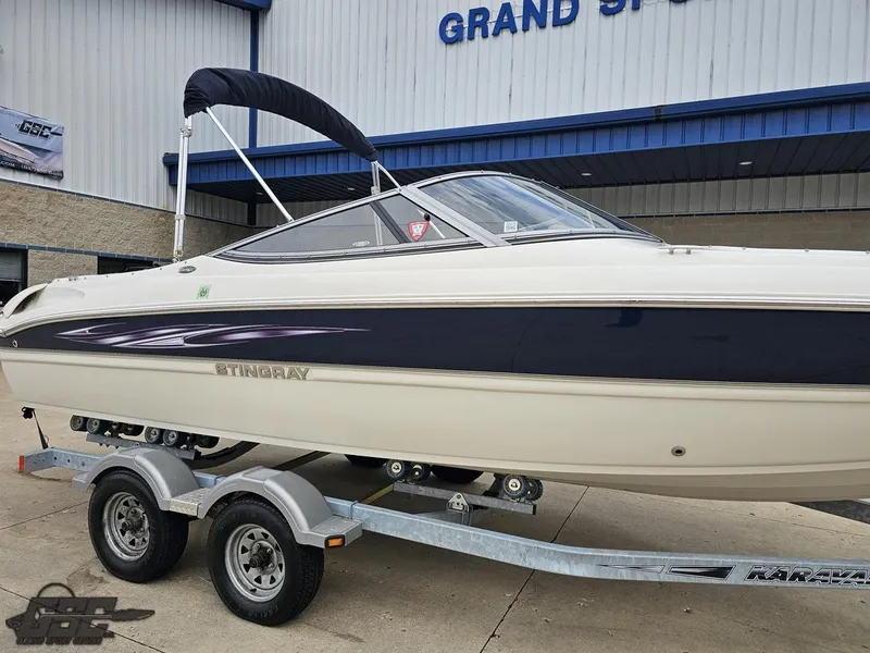 Slide: The Image of 2013 Stingray 225 LR boat on trailer outside dealership. - 9