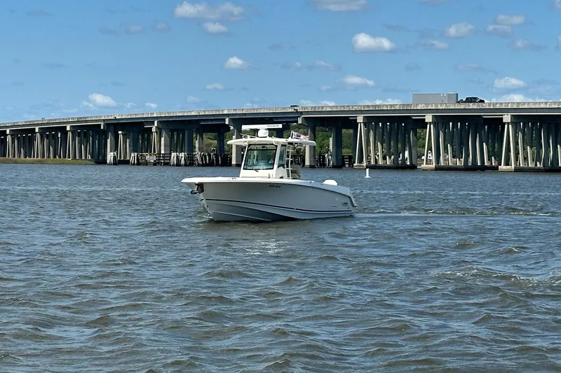 Slide: The Image of 2021 Boston Whaler 330 Outrage boat cruising near a bridge on a sunny day. - 13