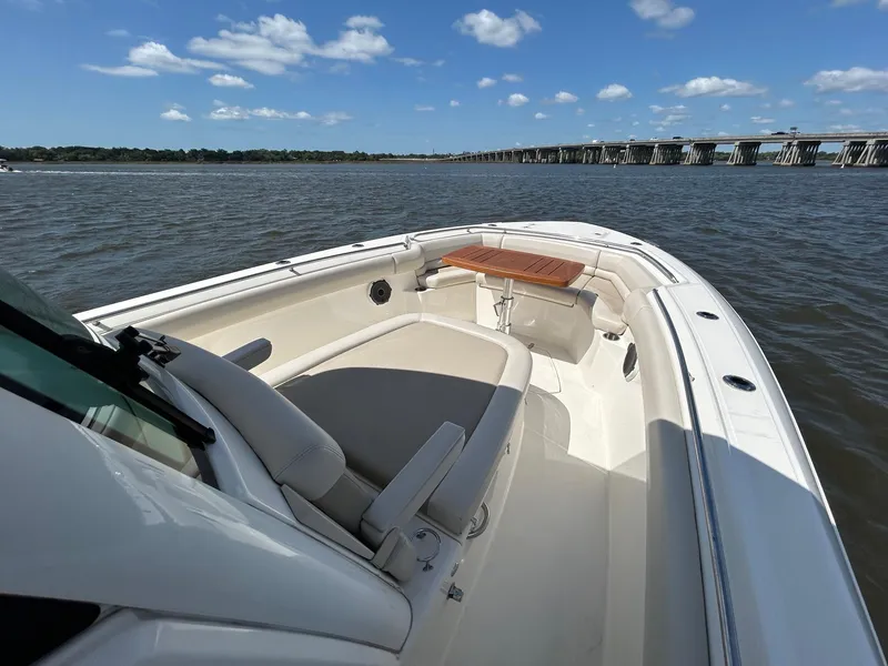 Slide: The Image of 2021 Boston Whaler 330 Outrage boat on calm water with bridge in background. - 14