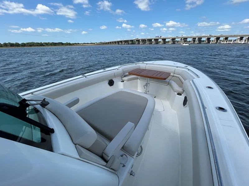 Slide: The Image of 2021 Boston Whaler 330 Outrage boat on water, featuring spacious seating and scenic view. - 15