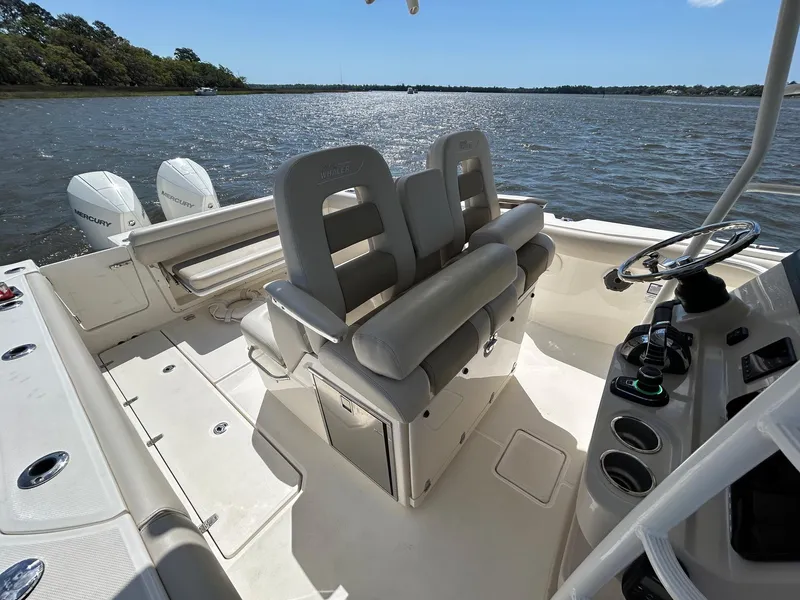 Slide: The Image of 2021 Boston Whaler 330 Outrage boat interior with dual seats and steering console on water. - 19