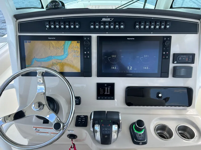 Slide: The Image of Boston Whaler 330 Outrage 2021 helm with dual displays and navigation controls. - 22
