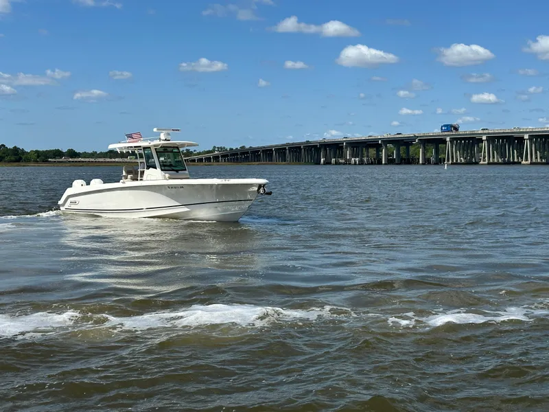 Slide: The Image of 2021 Boston Whaler 330 Outrage cruising on a sunny day near a bridge. - 7