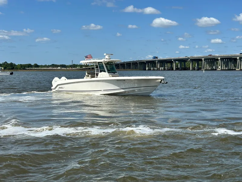 Slide: The Image of 2021 Boston Whaler 330 Outrage cruising on a sunny day near a bridge. - 8