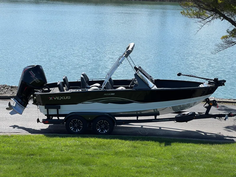 The Image of 2025 Vexus ADX190 boat on trailer by a lake, showcasing sleek design and modern features. - 1