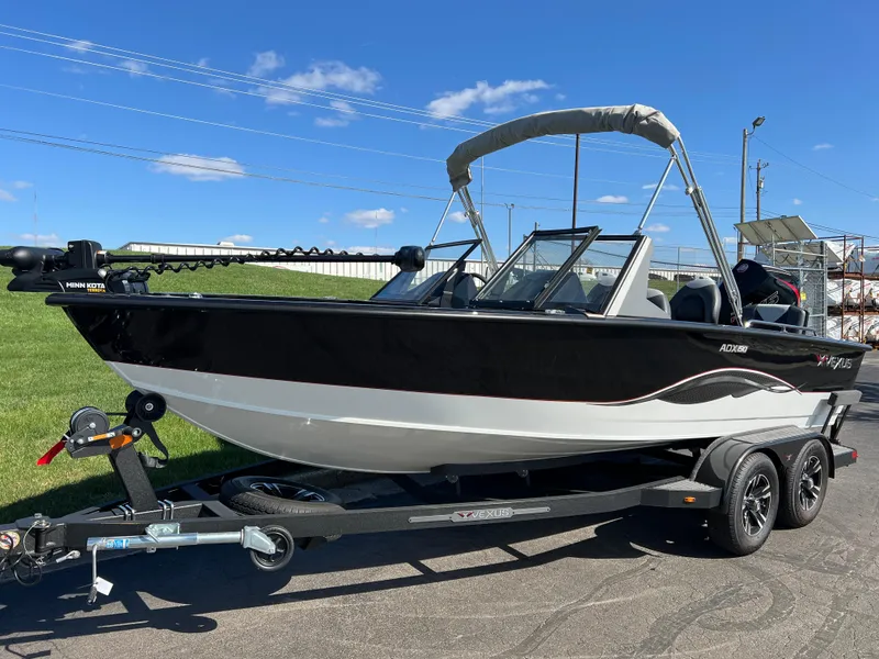 Slide: The Image of 2025 Vexus ADX190 boat on trailer, black and white design, sunny day. - 10