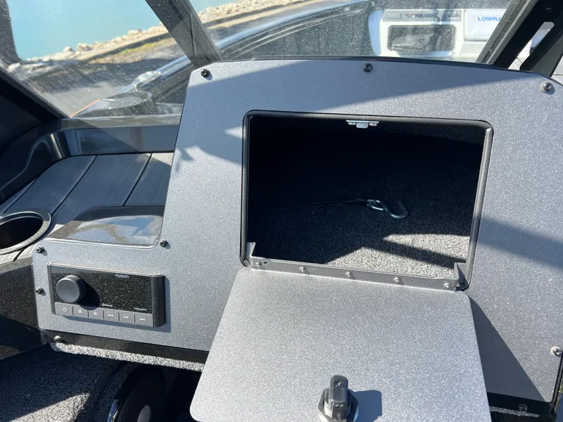 Slide: The Image of Interior of a 2025 Vexus ADX190 boat showing a storage compartment and control panel. - 17