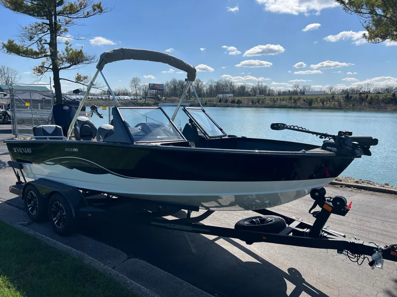 Slide: The Image of 2025 Vexus ADX190 boat on trailer by a scenic lake under a clear sky. - 2