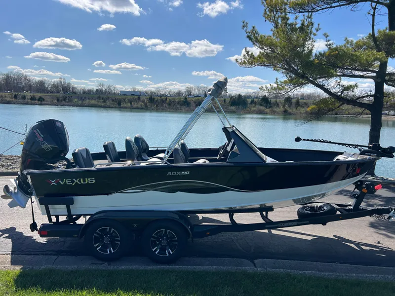 Slide: The Image of 2025 Vexus ADX190 boat on trailer by a scenic lake under a clear sky. - 3