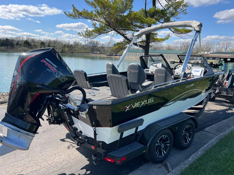 Slide: The Image of 2025 Vexus ADX190 boat on trailer by a lake, featuring sleek design and powerful engine. - 4