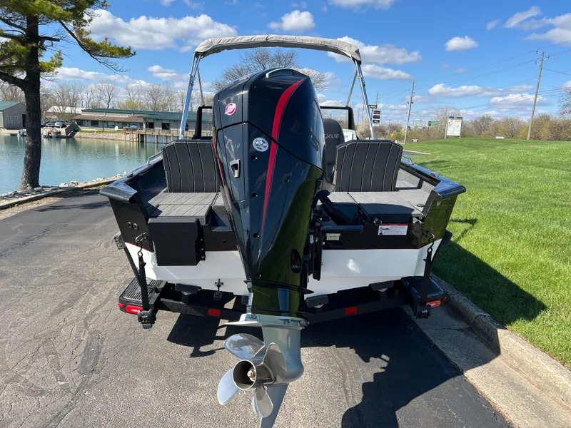 Slide: The Image of 2025 Vexus ADX190 boat with outboard motor, parked near a lake under a clear blue sky. - 5