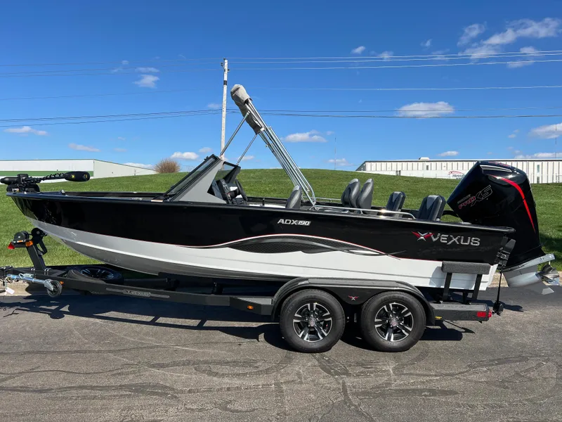 Slide: The Image of 2025 Vexus ADX190 boat on trailer, sleek black and white design, clear blue sky background. - 9