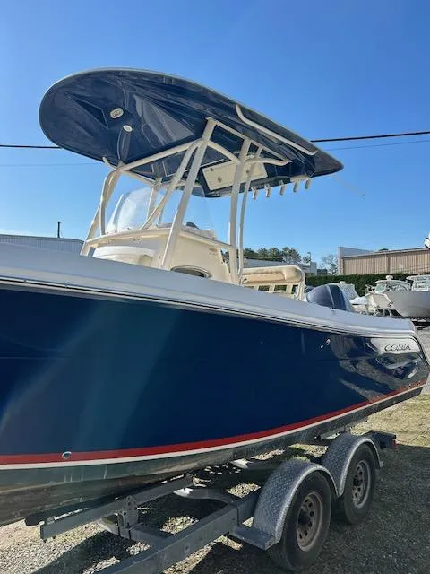 Slide: The Image of 2015 Cobia 237 Center Console boat on trailer, blue hull, sunny day. - 2