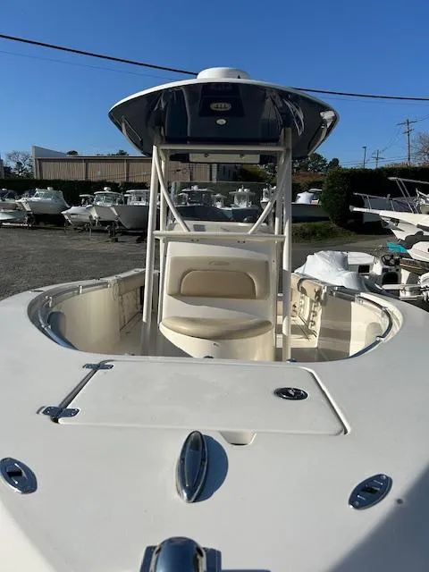 Slide: The Image of 2015 Cobia 237 Center Console boat, white exterior, docked in a marina under clear blue sky. - 3