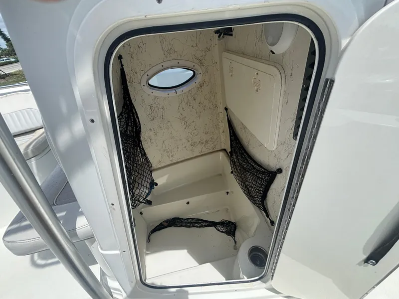 Slide: The Image of 2007 Sailfish 218 CC boat storage compartment with netting and porthole window. - 14