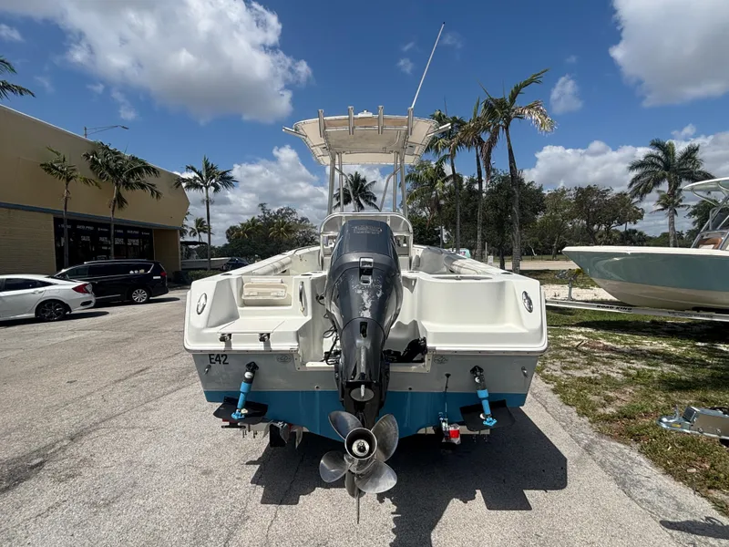 Slide: The Image of 2007 Sailfish 218 CC boat with outboard motor, parked outdoors under a sunny sky. - 2