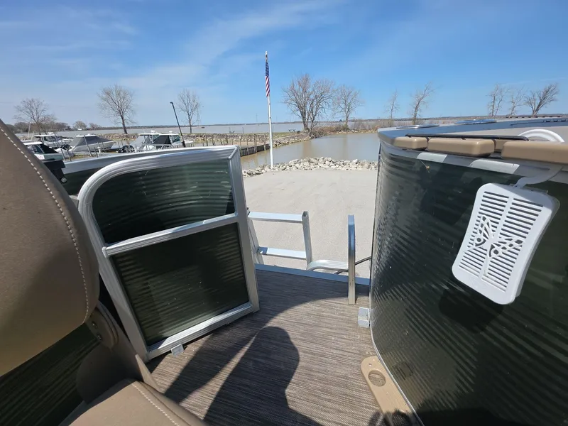 Slide: The Image of 2020 Bennington S 20 SS pontoon boat docked by a serene lakeside with clear blue skies. - 8