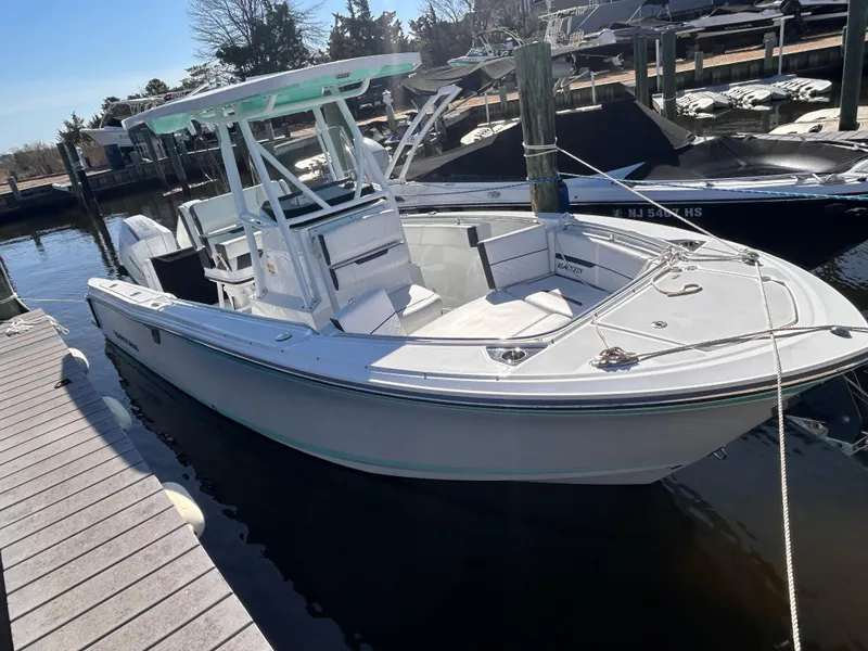 Slide: The Image of 2021 Blackfin 252 CC boat docked at marina, featuring sleek design and modern amenities. - 1