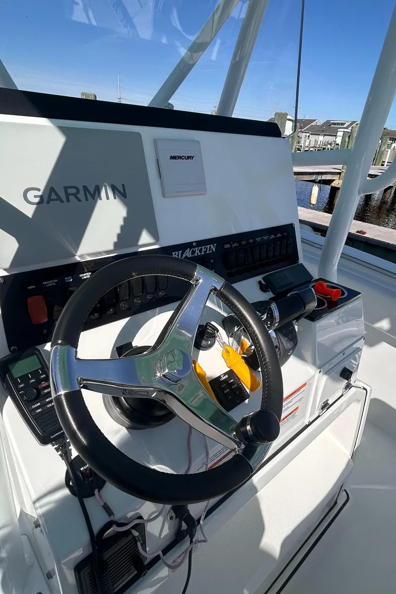 Slide: The Image of 2021 Blackfin 252 CC boat dashboard with Garmin navigation system and steering wheel. - 3