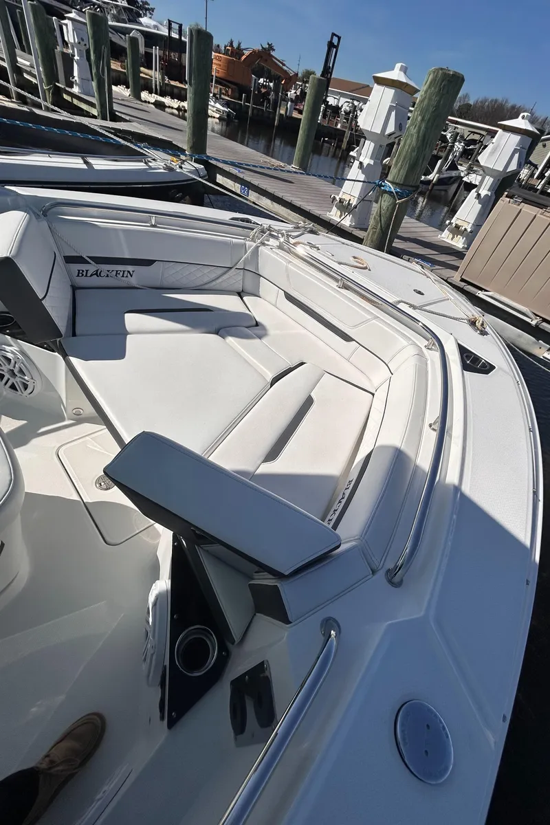 Slide: The Image of 2021 Blackfin 252 CC boat interior with white seating at a marina. - 7