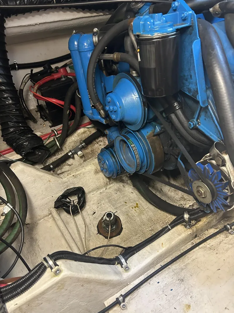 Slide: The Image of Engine compartment of a 1998 Pursuit 3400 Express boat, featuring blue engine components. - 14