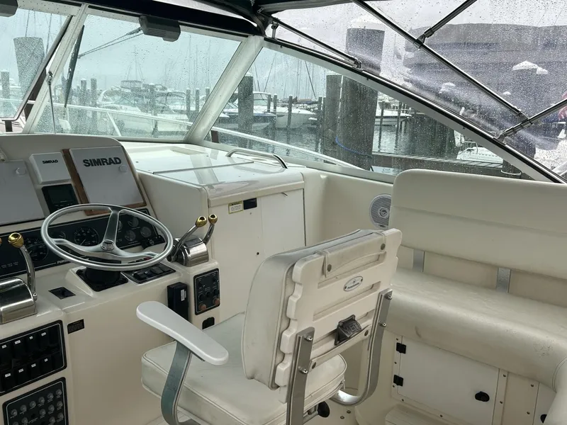 Slide: The Image of 1998 Pursuit 3400 Express boat cockpit with steering wheel and Simrad navigation system. - 6