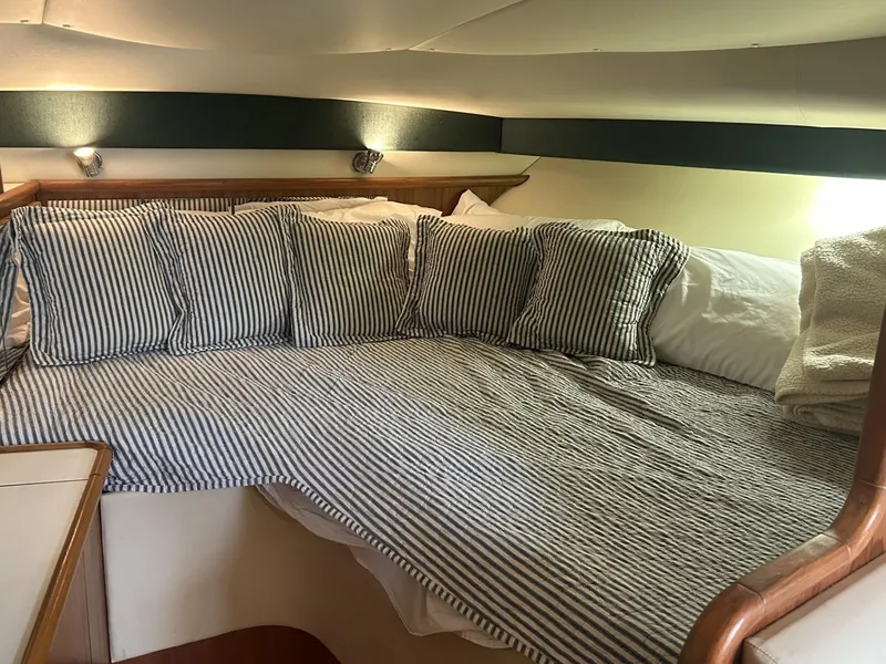 Slide: The Image of Cozy cabin interior of 1998 Pursuit 3400 Express with striped bedding and pillows. - 8