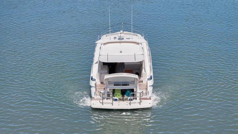 Slide: The Image of 2020 Riviera 4800 Sport Yacht cruising on calm waters, rear view. - 10