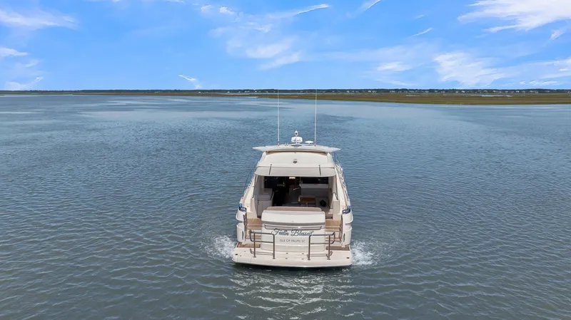 Slide: The Image of 2020 Riviera 4800 Sport Yacht cruising on open water under a clear blue sky. - 16