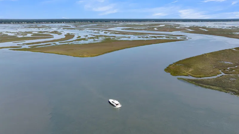 Slide: The Image of Aerial view of 2020 Riviera 4800 Sport Yacht cruising through serene coastal waters. - 17