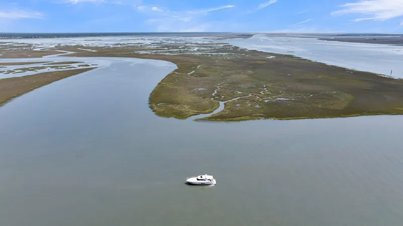 Slide: The Image of Aerial view of 2020 Riviera 4800 Sport Yacht cruising in serene coastal waters. - 18