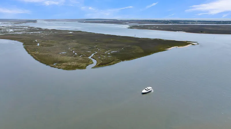 Slide: The Image of Aerial view of 2020 Riviera 4800 Sport Yacht on calm waters near a lush island. - 19