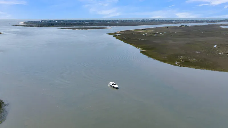 Slide: The Image of Aerial view of 2020 Riviera 4800 Sport Yacht cruising on a wide, calm river. - 20