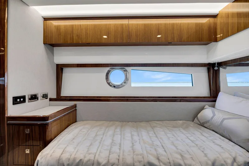 Slide: The Image of Luxurious bedroom interior of 2020 Riviera 4800 Sport Yacht with wood accents and ocean view. - 45