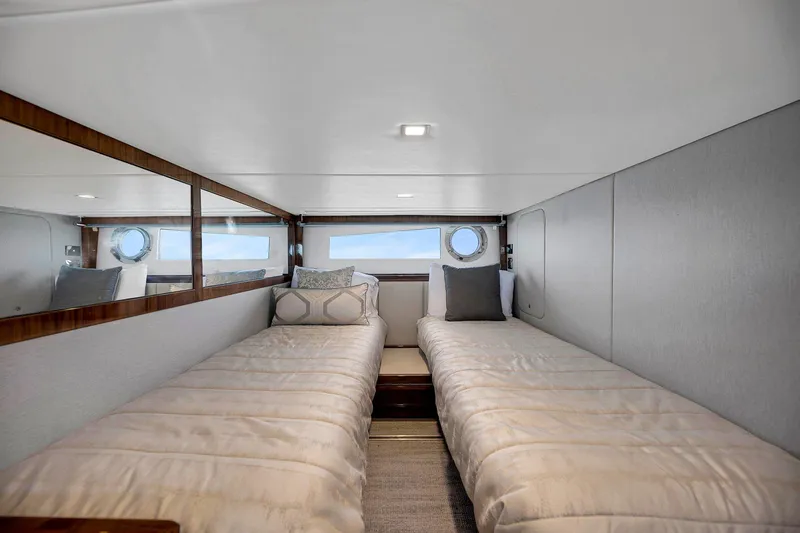 Slide: The Image of Twin beds in a 2020 Riviera 4800 Sport Yacht cabin with modern decor. - 46