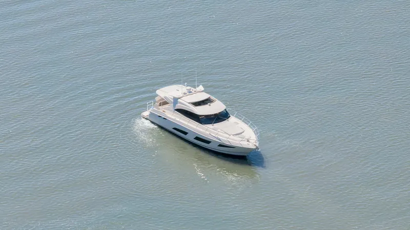 Slide: The Image of 2020 Riviera 4800 Sport Yacht cruising on calm waters. - 8