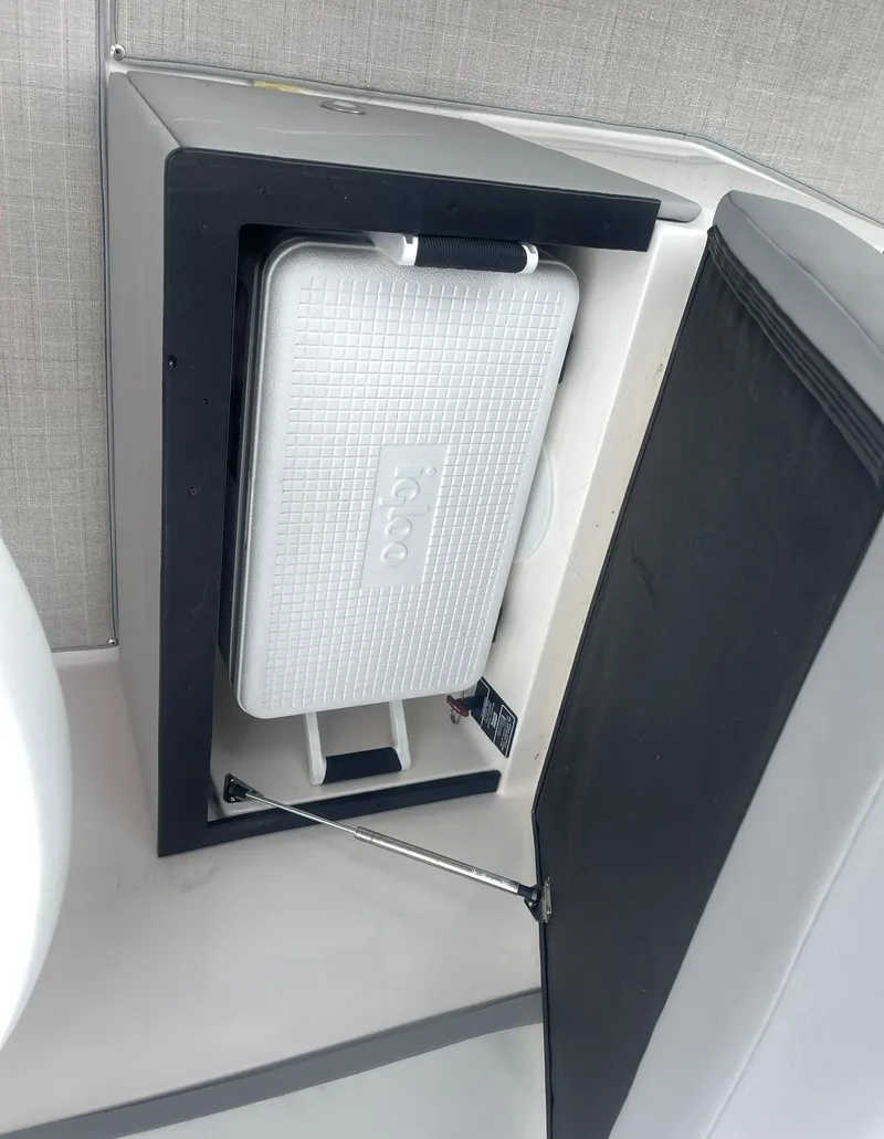 Slide: The Image of 2024 Regal 26 XO boat interior with built-in cooler storage compartment. - 11