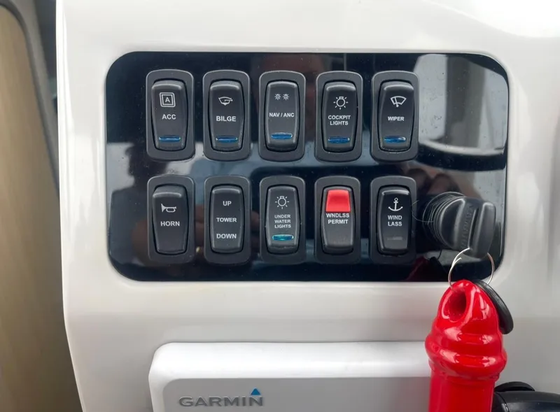 Slide: The Image of Control panel of 2024 Regal 26 XO boat with labeled switches and Garmin device. - 14
