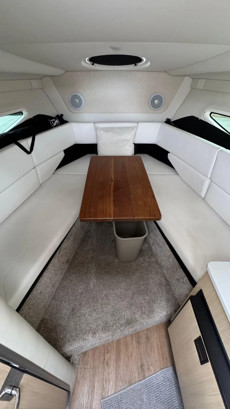 Slide: The Image of 2024 Regal 26 XO cabin interior with white seating and wooden table. - 19
