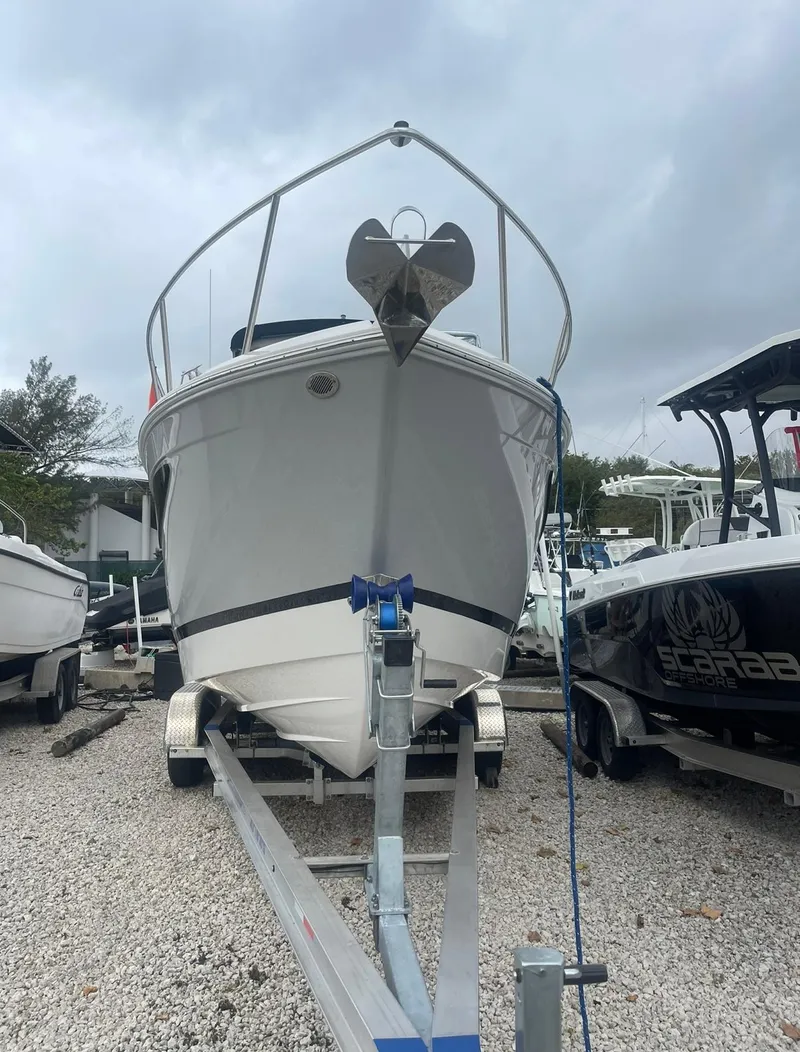 Slide: The Image of 2024 Regal 26 XO boat on trailer, front view, overcast sky. - 2