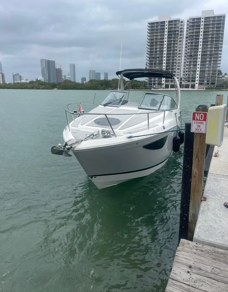 Slide: The Image of 2024 Regal 26 XO boat docked in urban marina with city skyline. - 25