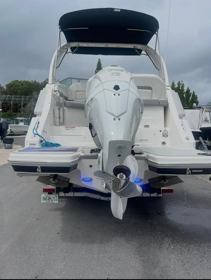 Slide: The Image of 2024 Regal 26 XO boat with outboard motor, docked on a cloudy day. - 4