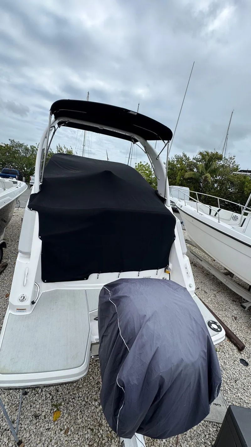 Slide: The Image of 2024 Regal 26 XO boat with cover, docked under cloudy skies. - 6