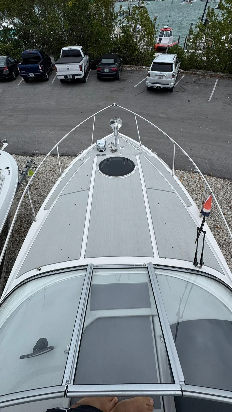 Slide: The Image of 2024 Regal 26 XO boat docked, aerial view showing bow and parking lot. - 8