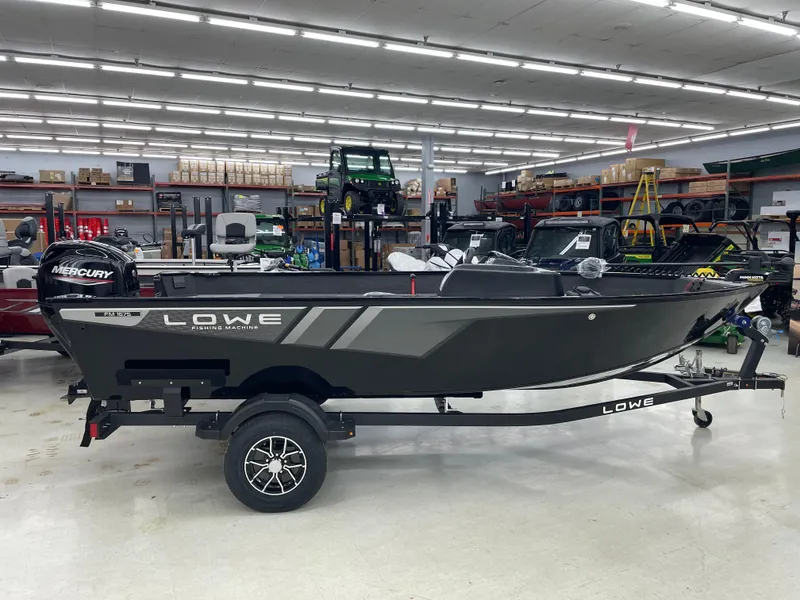 Slide: The Image of 2025 Lowe FM1675S fishing boat in showroom, featuring sleek design and Mercury engine. - 1