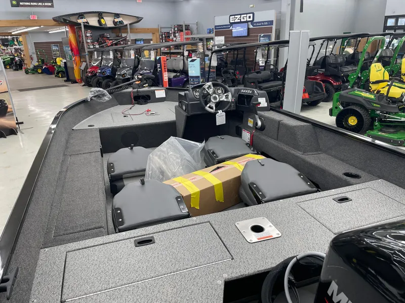 Slide: The Image of 2025 Lowe FM1675S boat displayed in showroom, surrounded by various vehicles. - 11