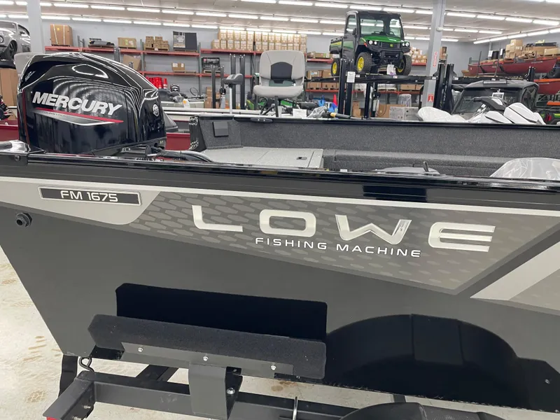 Slide: The Image of 2025 Lowe FM1675S Fishing Machine boat with Mercury engine in showroom. - 2